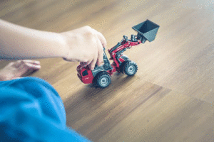child's hand with toy construction digger